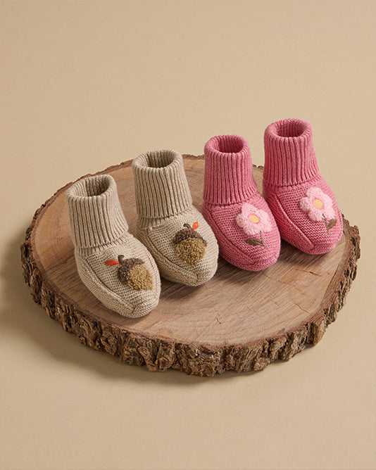 baby booties on wooden log